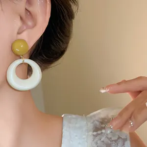 Orecchini retrò in acrilico con perno giallo senape e anello circolare bianco crema