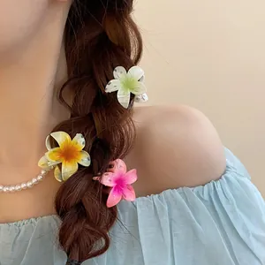 Vue détaillée de trois mini-pinces à cheveux en forme de lis portées dans une tresse
