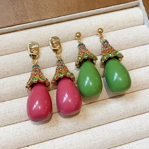 Detailed macro view of vintage resin teardrop earrings featuring colorful rhinestone accents