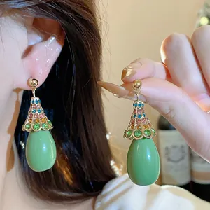 Detail view of vintage green resin water drop earrings with colorful rhinestone accents.