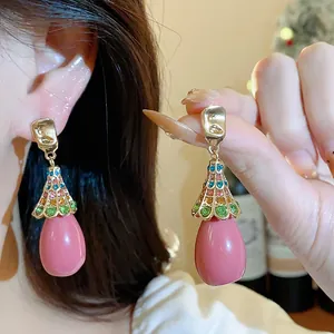 Vintage pink resin teardrop earrings with colorful rhinestones in a gold finish.