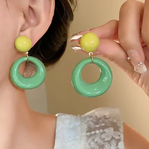 Primo piano di orecchini pendenti in acrilico verde menta e giallo