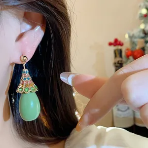 Macro view of vintage style waterdrop dangle earrings with colorful rhinestones on ear