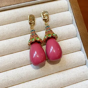 Close-up of vintage resin drop earrings with colorful rhinestones in a display box