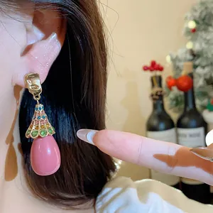 Close-up of vintage resin drop earrings with colorful rhinestones on a silver needle