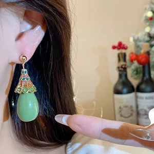 Detailed close-up of vintage-style green resin teardrop earrings with colorful rhinestones