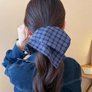 Blue plaid double-layer cloth scrunchie on long brown hair in a casual lifestyle setting
