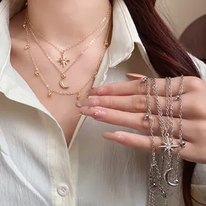 Close-up detail showing layered star and moon pendant necklaces in gold and silver finishes