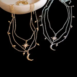 Close-up of elegant gold and silver layered necklaces with rhinestone star and moon charms