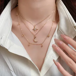 Detailed macro view of a stylish three-layer gold star and moon pendant necklace jewelry