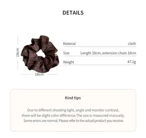 Detailed view of a brown checkered fabric scrunchie with 18cm measurements