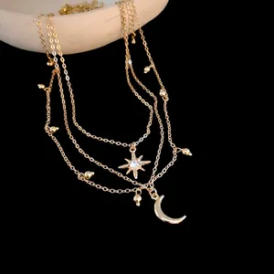 Detail view of a gold-layered necklace featuring rhinestone star and crescent moon charms.