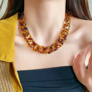 Close-up view of retro leopard print acrylic chunky chain necklace worn by a model.