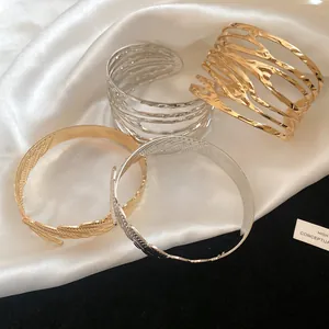 Macro detail of vintage gold and silver metal open bangles with twisted feather designs