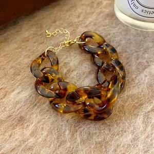 Close-up of retro tortoise shell acrylic chain necklace with gold-tone clasp and link