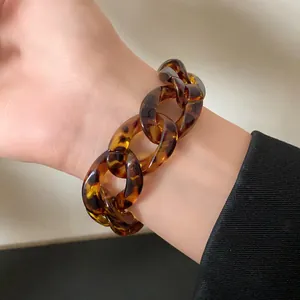 Close-up detail of a vintage leopard print acrylic chunky chain bracelet on a wrist
