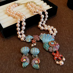 Detailansicht einer zweilagigen rosa Perlenkette mit farbenfrohem Strass-Muschelanhänger