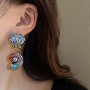 Nahaufnahme eines Models mit Vintage-Ohrringen aus Regenbogen-Strass und Muscheln