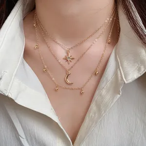 Elegant multilayered gold necklace with sparkling star and crescent moon pendants.
