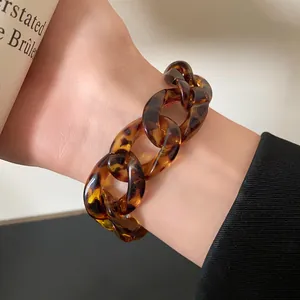 Close-up of a vintage leopard print acrylic chunky chain link bracelet on a woman's wrist