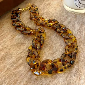 Macro view of chunky tortoiseshell resin chain necklace with warm amber tones