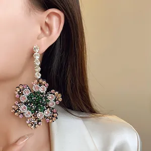 Gros plan détaillé de boucles d'oreilles fleurs avec strass multicolores étincelants