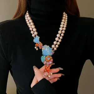 Detailaufnahme einer Vintage-Doppel-Perlenkette mit bunten Muschel- und Seesternanhängern.