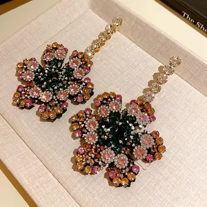 Vue macro de boucles d'oreilles fleurs en strass avec cristaux multicolores brillants