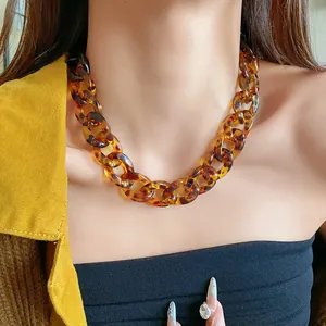 Detailed macro view of a retro tortoiseshell resin chain necklace on a model