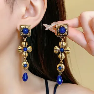 Vintage gold-toned flower earrings with blue drop stones for an elegant palace style look.