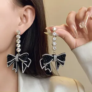 Gros plan détaillé de boucles d'oreilles à nœud en cristal portées par un mannequin