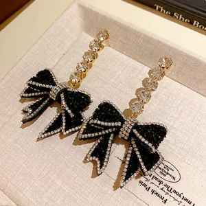 Détail macro de boucles d'oreilles en argent avec nœuds en strass noirs et cristaux