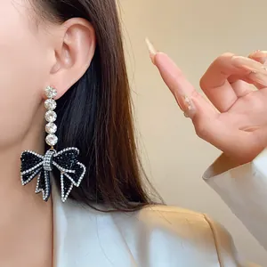 Gros plan de boucles d'oreilles pendantes en strass noirs portées par un mannequin