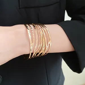 Detailed close-up of a gold distorted organic metal open cuff bracelet on wrist