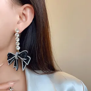 Détail d'une boucle d'oreille nœud noir de luxe avec des cristaux étincelants