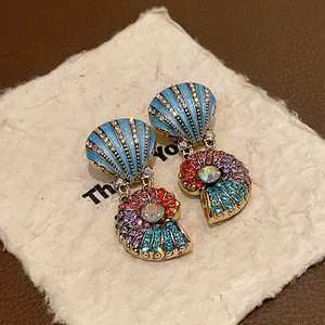 Nahaufnahme von Vintage-Nautilus-Schmuck mit blauer Emaille und bunten Regenbogen-Steinen.