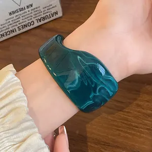 Detailed view of a dark green marbled resin bangle with irregular retro wavy design