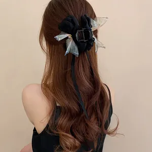 Detailansicht einer eleganten Schmetterling-Haarklammer mit Perlen in braunem Haar