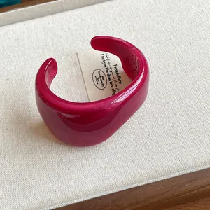 Close-up of deep pink translucent resin cuff bracelet with irregular marbled texture