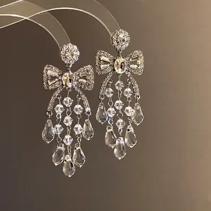 Elegant sparkling crystal bow tassel earrings with dangling raindrops in silver finish.