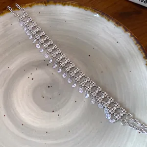 Elegant multi-row silver choker necklace with shimmering cubic zirconia teardrop charms.