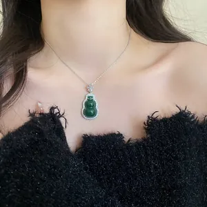 Detail view of a green resin gourd pendant necklace with zircon embellishments on a model.