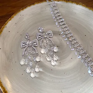 High-quality detailed shot of sparkling zirconia bow earrings and matching necklace set