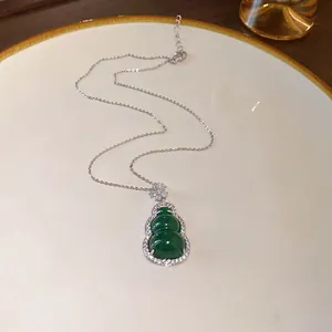 Detailed view of a green resin gourd pendant necklace surrounded by sparkling zircons