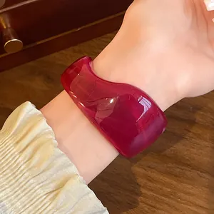 Detailed macro view of a vintage deep red translucent irregular resin cuff bracelet