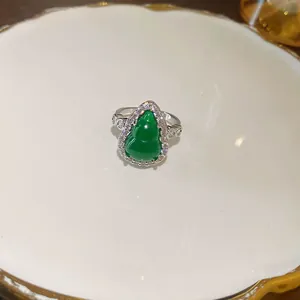 Close-up of a vintage-style ring featuring a green resin gourd and zircons