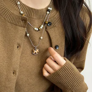 Close-up of vintage Maillard style double-layer necklace with wooden rocking horse