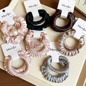 Set of elegant pleated fabric scrunchies in neutral colors featuring a pearl accent