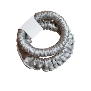 Elegant silver pleated satin hair scrunchie with elastic band on white background