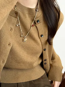 Detail view of vintage wooden rocking horse beaded necklace on a brown knit sweater